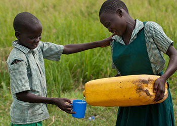 Tomando algo de beber en la escuela primaria Olikwi. Muchos de los niños de Olikwi recientemente regresaron del exilio de la última guerra. Foto de Karen Kasmauski para CRS