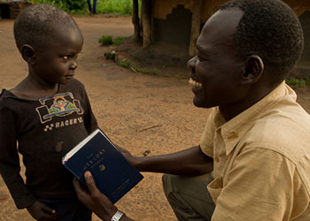 El compromiso con la comunidad fomenta la confianza y la paz en el sur de Sudán asolado por la guerra. El padre Joseph Otto de la parroquia Sta. Teresa en Magwi saluda a un niño después de misa. Foto de Karen Kasmauski para CRS