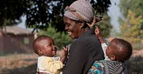 Rose Mimba, de 61 años, es una de muchas mujeres que viven en Karonga, Malawi. Esta área tiene una alta concentración de personas infectadas con el virus del sida, además de un gran porcentaje de niños desnutridos. CRS trabaja con un socio local, "Lusubilo Community Orphan Care" para llevar alimentos a los niños de la comunidad que sufren de malnutrición. Rosa, al igual que muchas mujeres mayores de estas comunidades en Malawi y en otras partes de África, cuida de sus nietos pues su madre falleció al dar a luz a las gemelas Brenda y Linda, a quienes sostiene en la imagen.