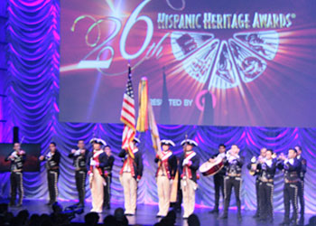 La escolta ondeando la bandera estadounidense al frente del escenario, mientras que el mariachi tocaba el himno nacional durante la inauguración de los premios. Foto por Christian Meléndez López