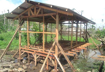 CRS ayuda a filipinos desplazados a construir refugios temporales utilizando la madera de sus casas dañadas por el Tifón Haiyan. 