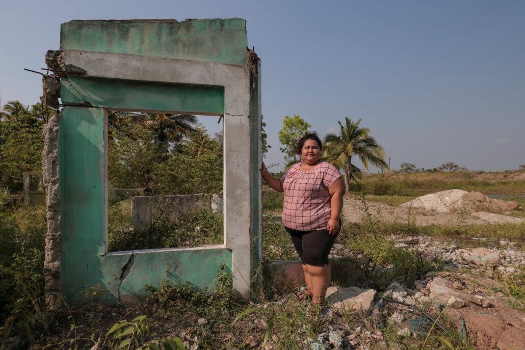 mujer hondureña posa frente a las ruinas de su hogar luego de las tormentas ETA e Iota