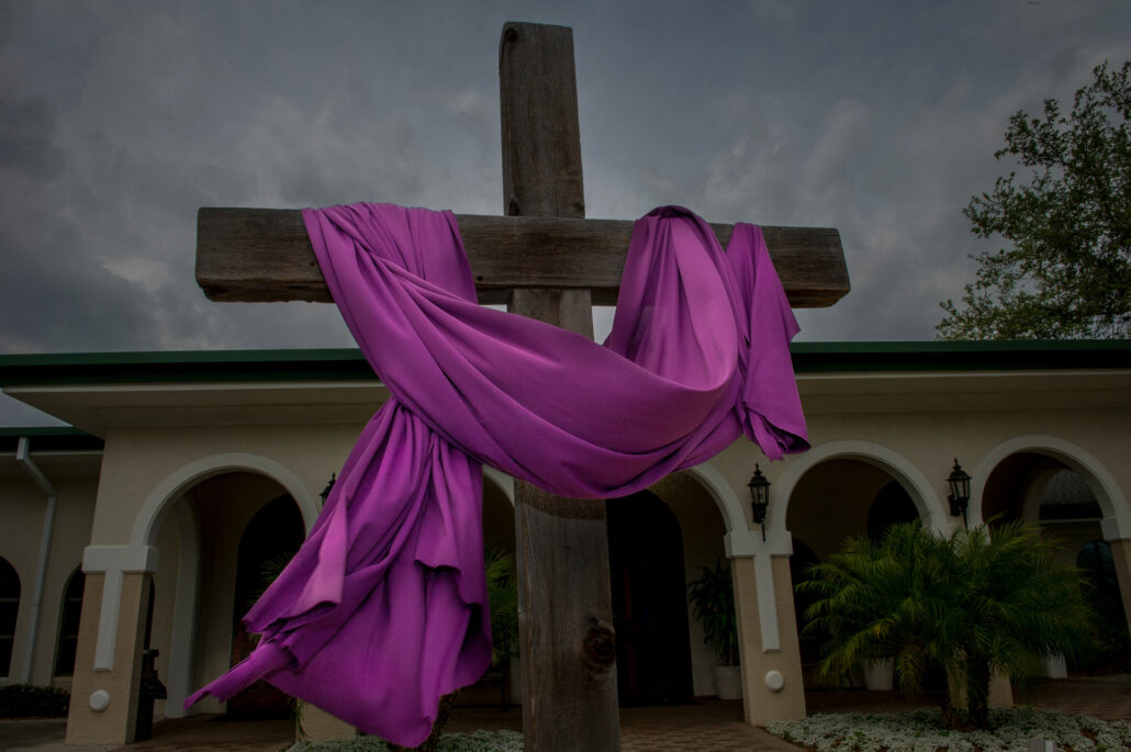 cruz decorada con un manto morado