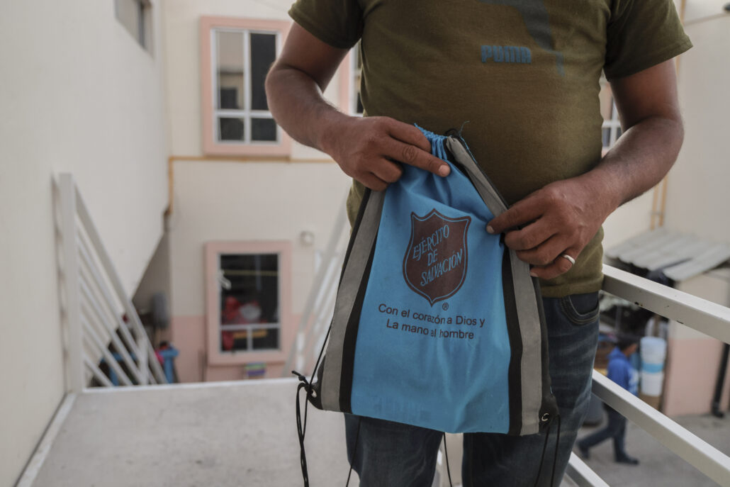 migrante climatico muestra una mochila donde lleva todas sus pertenencias