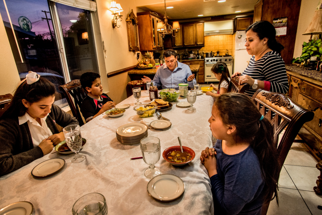 familia reunida en la mesa agradecen a dios por sus alimentos
