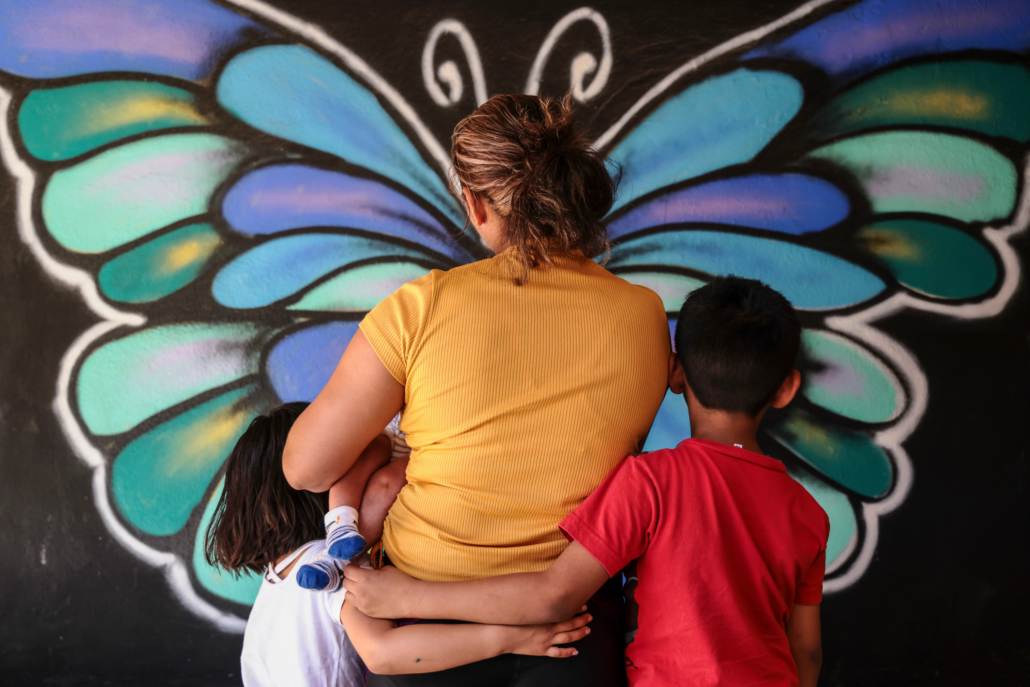 mujer migrante con sus tres hijos